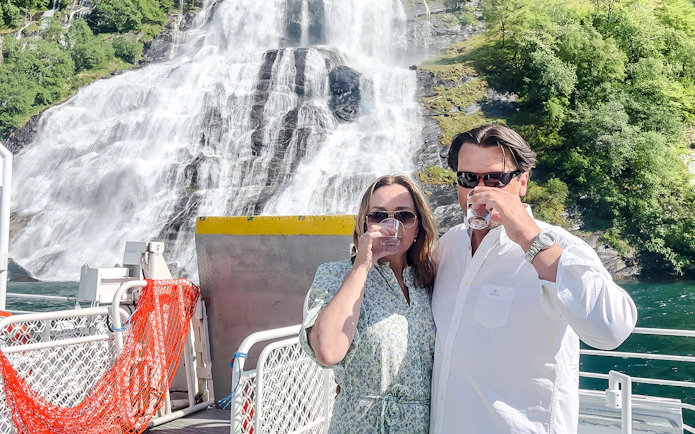 Couple enjoying waterfall tasting on Geiranger Fjord boat tour.