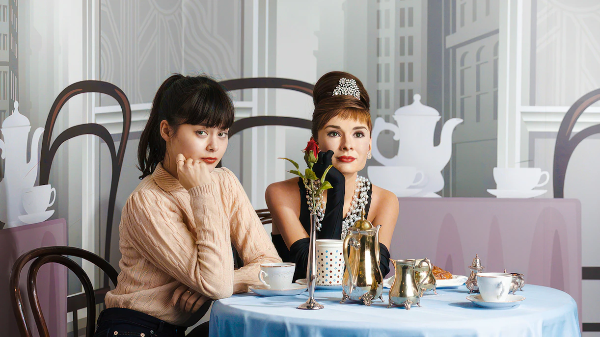 Two women sitting at a table with tea set at Madame Tussauds Tokyo.