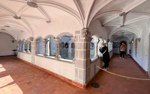 Sintra's Pena Palace interior corridor with visitors, showcasing Gothic architecture.