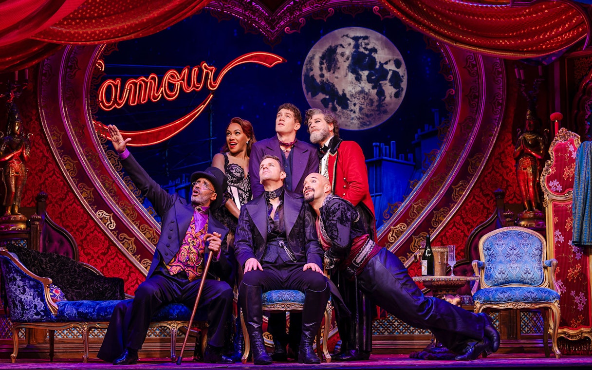 Cast performing on stage at Moulin Rouge! The Musical, West End, with vibrant set design.