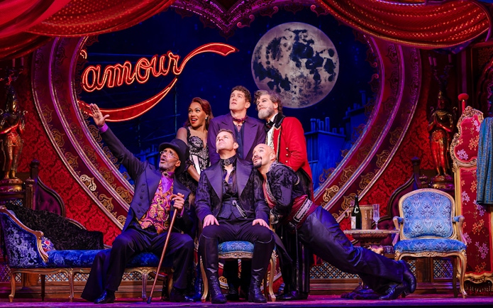 Cast performing on stage at Moulin Rouge! The Musical, West End, with vibrant set design.