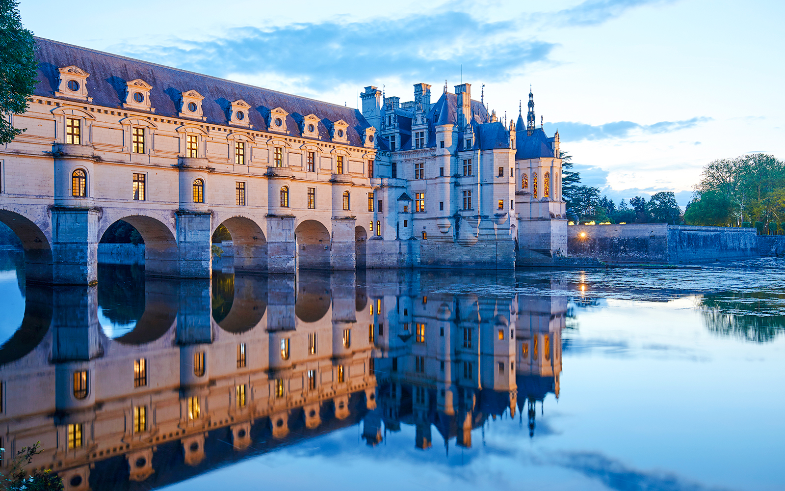 Chenonceau Castle reflecting in the river at dusk, Loire Valley, France.