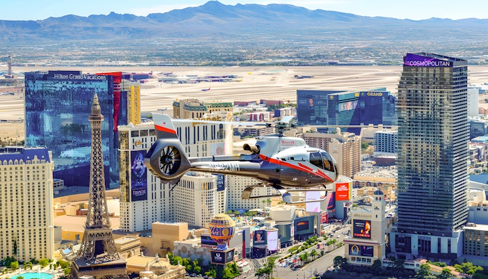 Maverick Helicopter flying over the Las Vegas Strip with cityscape view.