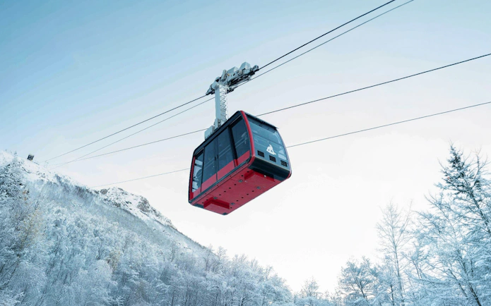 Cable car ascending snowy mountain in Fjellheisen, Tromsø.