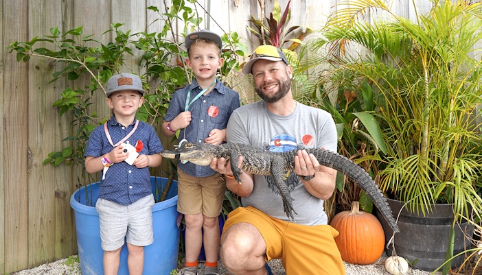 Guests holding a small alligator at Everglades Holiday Park animal encounter.