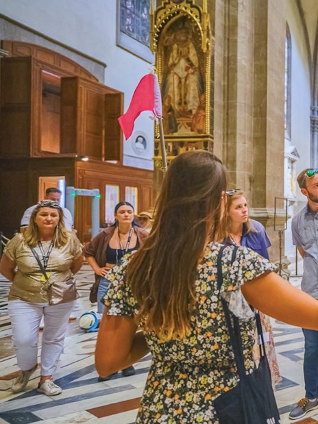 Tour group listening to guide inside Florence Cathedral.