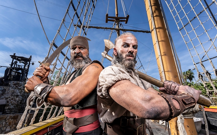 Pirates on a ship at Isla Magica, preparing for a battle with swords and axes.
