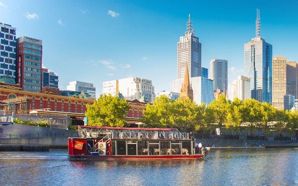 Cruise boat on Yarra River with Melbourne skyline in the background.