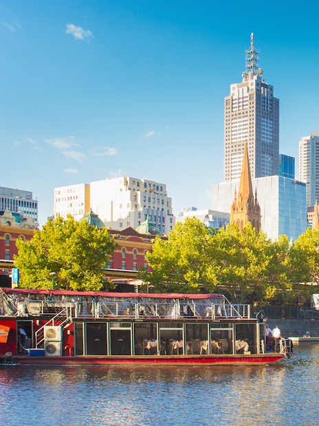 Cruise boat on Yarra River with Melbourne skyline in the background.