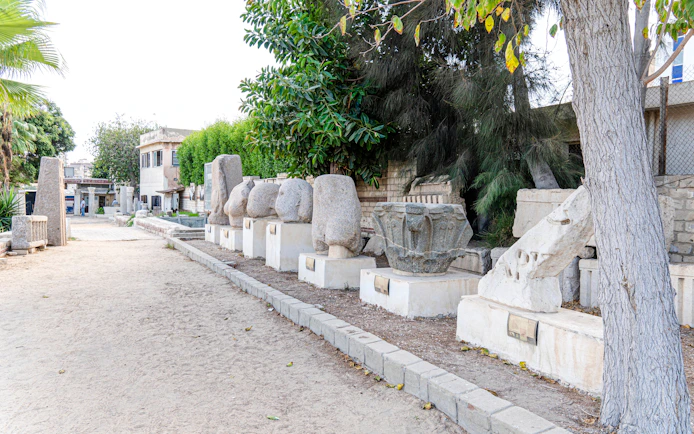 Ancient Roman stone artifacts displayed outdoors in Alexandria, Egypt.