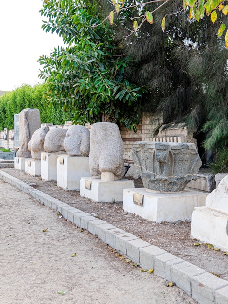 Ancient Roman stone artifacts displayed outdoors in Alexandria, Egypt.