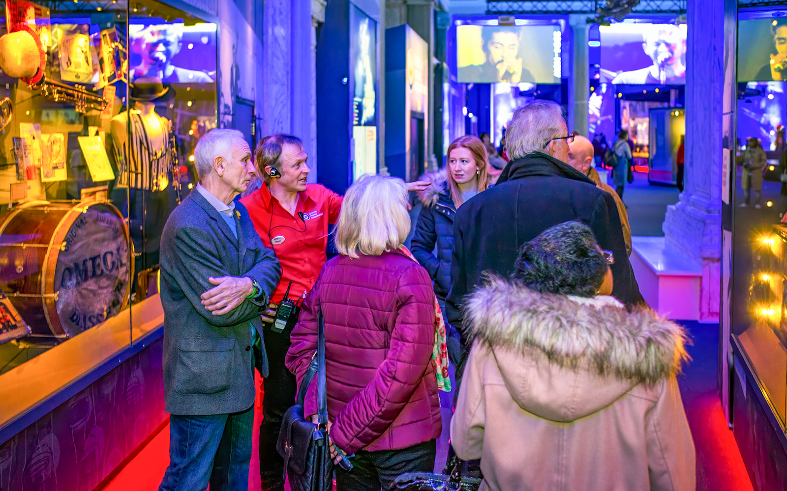 Group tour inside the British Music Experience, Liverpool, with guide explaining exhibits.