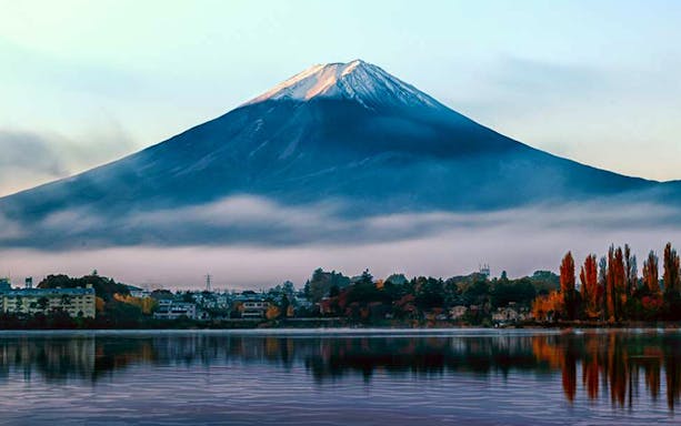 Mount Fuji with mist and autumn trees reflected in a lake, viewed from Tokyo day tour.