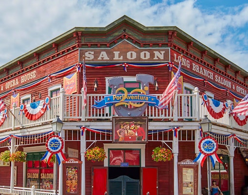 PortAventura Park Wild West themed area with wooden buildings and visitors exploring.