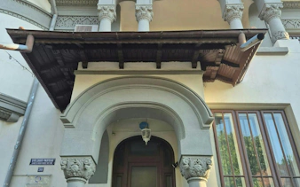 Ornate entrance of a historic building on Strada Louis Pasteur, Bucharest, featured in a self-guided city exploration game.