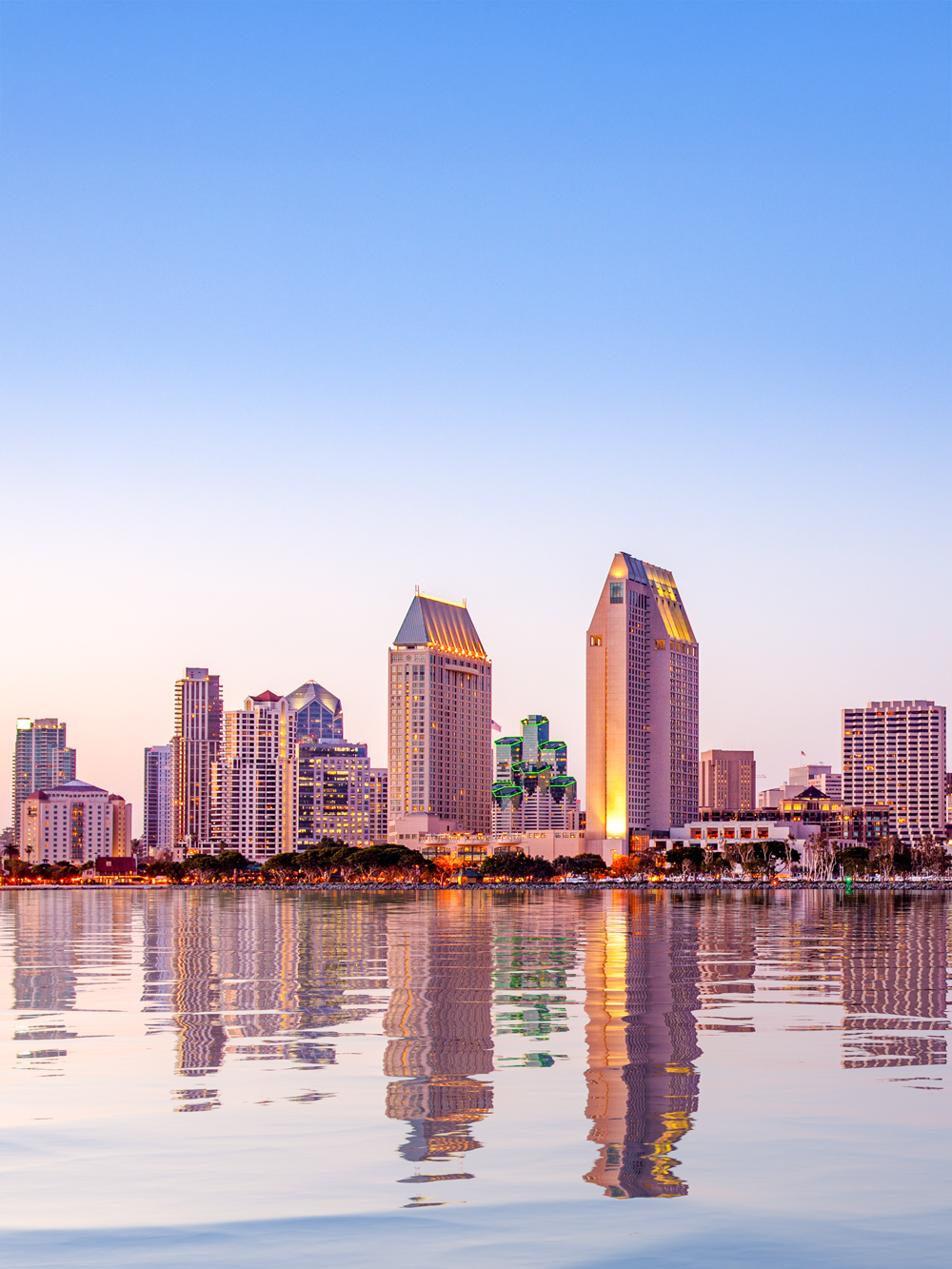 San Diego skyline reflecting on water at sunset.