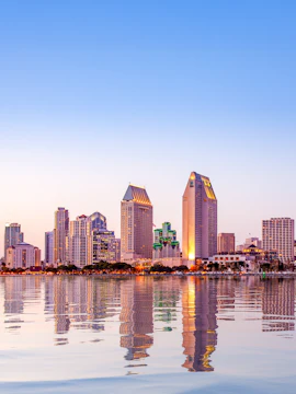 San Diego skyline reflecting on water at sunset.
