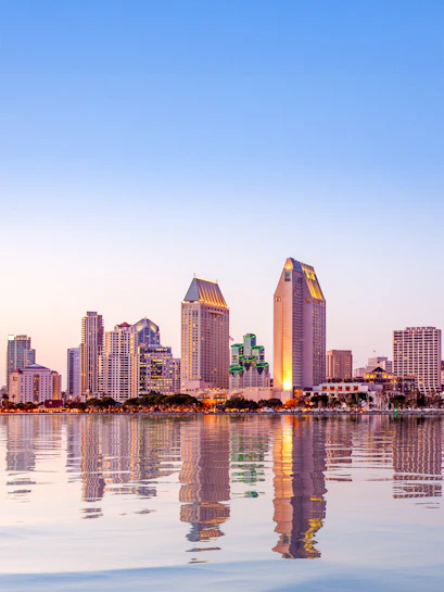 San Diego skyline reflecting on water at sunset.