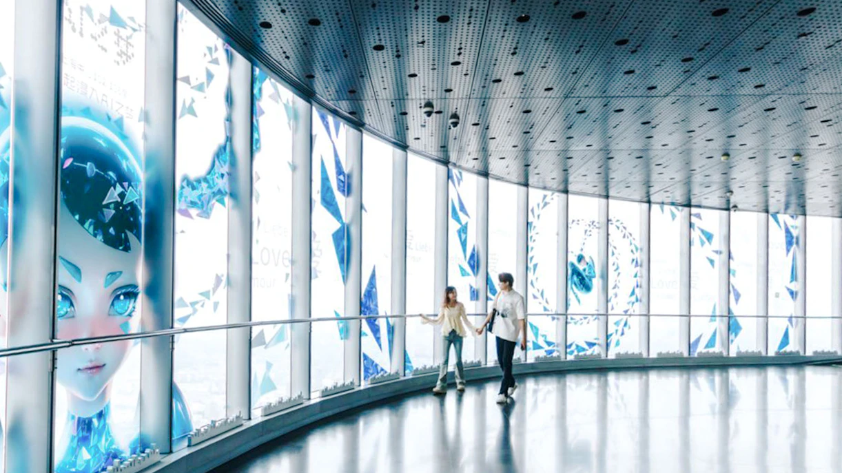 Visitors walking inside Shanghai Tower observation deck with digital art displays.