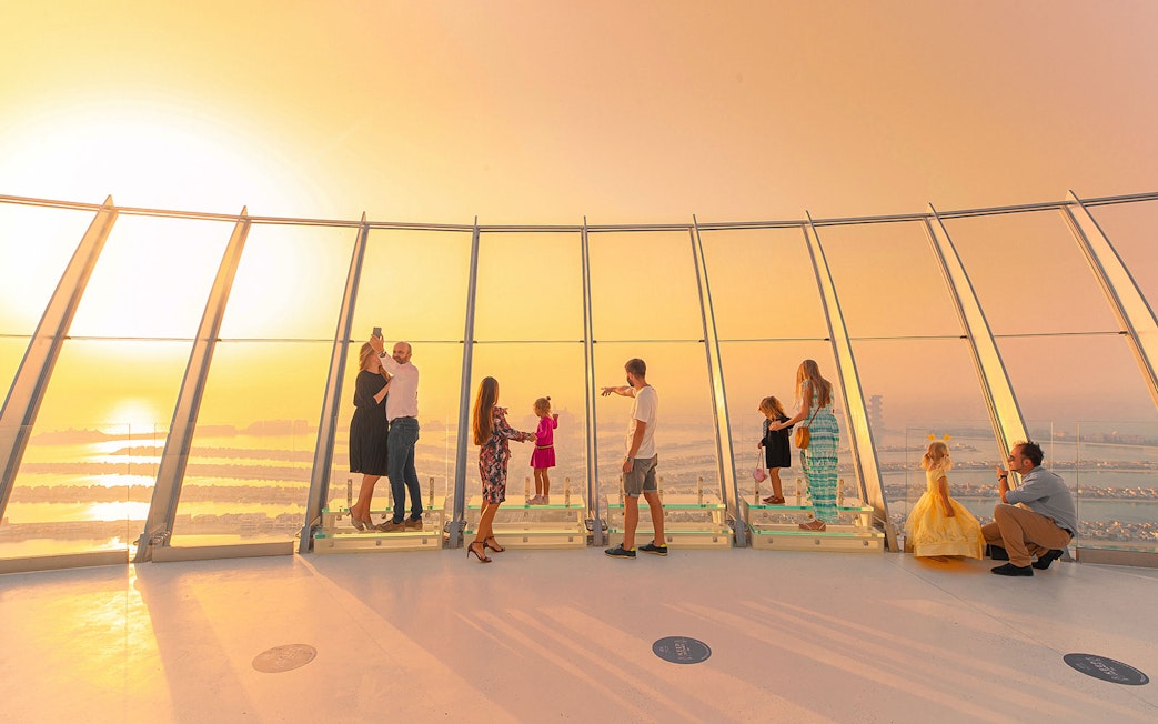 Visitors enjoying sunset views from The View at The Palm observation deck in Dubai.