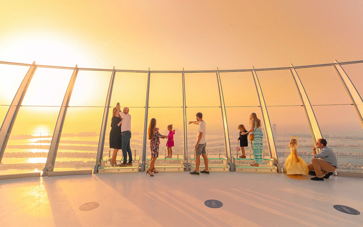 Visitors enjoying sunset views from The View at The Palm observation deck in Dubai.