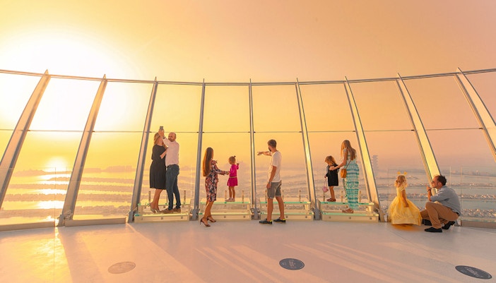 Visitors enjoying sunset views from The View at The Palm observation deck in Dubai.