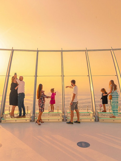 Visitors enjoying sunset views from The View at The Palm observation deck in Dubai.