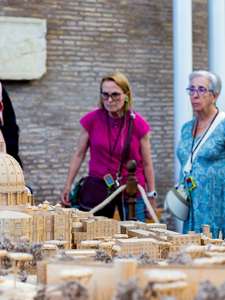 Tour group examining Vatican model at Vatican Museums, Rome.