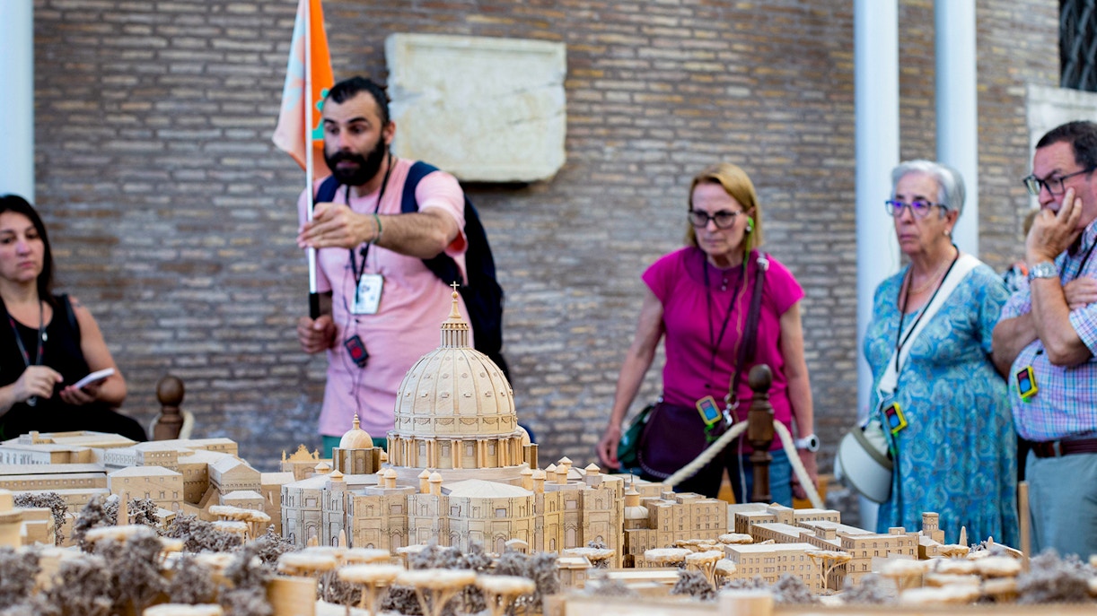 Tour group examining Vatican model at Vatican Museums, Rome.