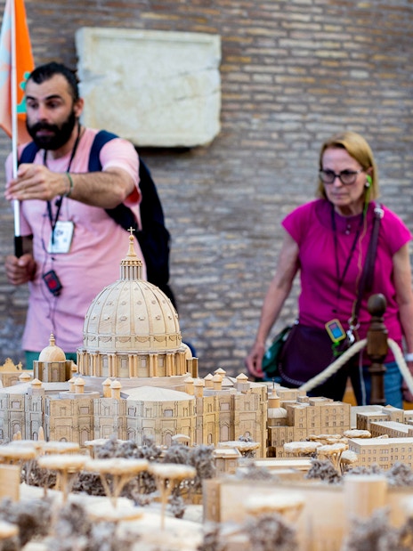 Tour group examining Vatican model at Vatican Museums, Rome.