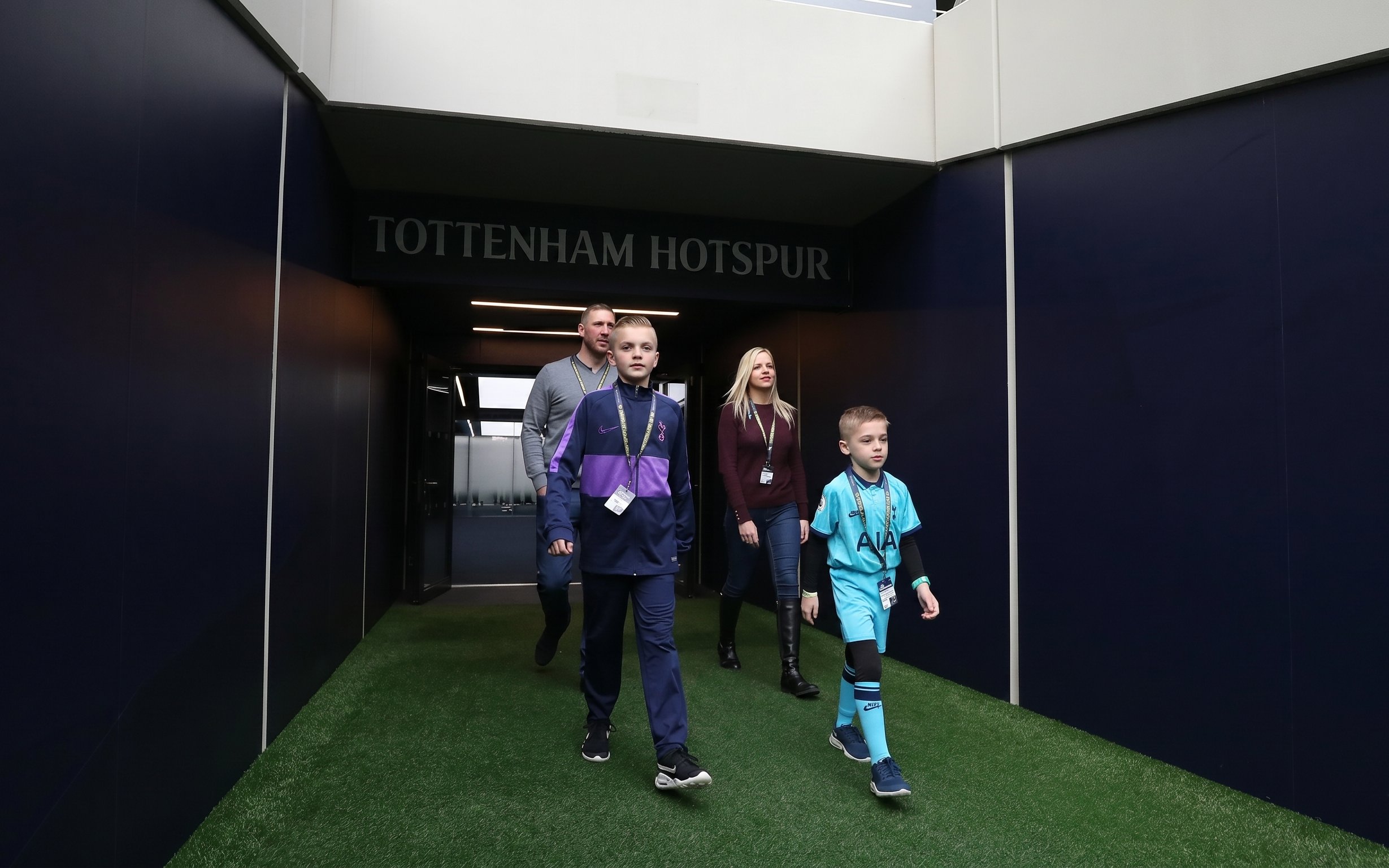 Visitors walking through the Tottenham Hotspur Stadium tunnel during a tour.