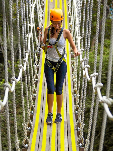 Person crossing a rope bridge at Habitat Penang Hill.