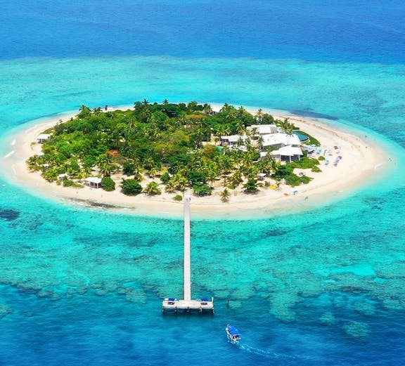Aerial view of Mala Mala Island, Fiji with a pier extending into turquoise waters.