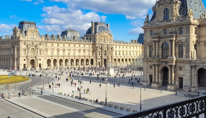 Louvre Museum exterior with courtyard and glass pyramid in Paris.