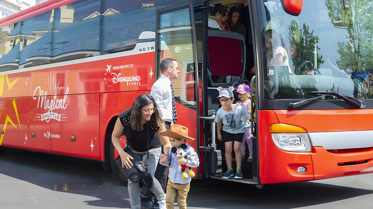 Families disembark Magic Shuttle bus at Disneyland Paris entrance.