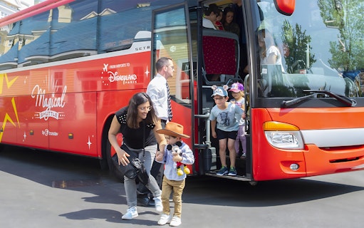 Families disembark Magic Shuttle bus at Disneyland Paris entrance.