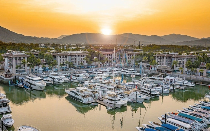 Speedboats docked at Royal Phuket Marina at sunset, departure point for James Bond Island tour.