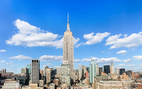 Empire State Building under a clear blue sky in Manhattan, NYC.