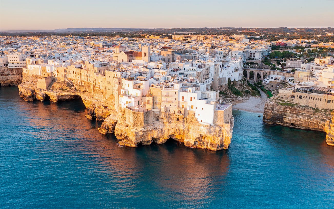 Polignano a Mare cliffside view with white buildings above the Adriatic Sea.