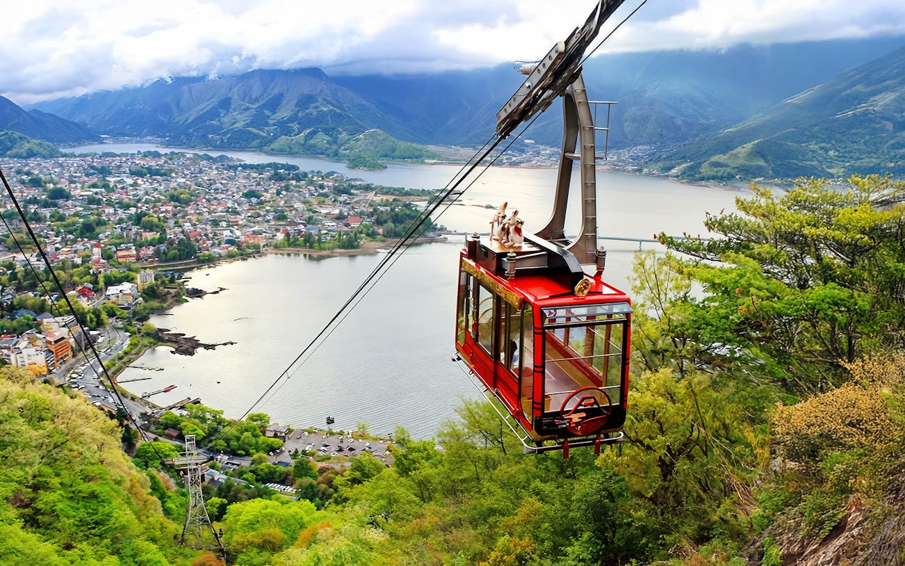 Mt Kachi Ropeway cable car ascending with view of Lake Kawaguchi and Mount Fuji in Japan.
