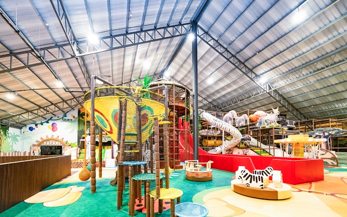 Indoor safari-themed playland with climbing structures and animal figures.