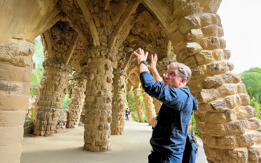 Guide explaining stone columns in Park Guell during a tour in Barcelona, Spain.