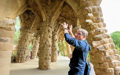 Guide explaining stone columns in Park Guell during a tour in Barcelona, Spain.