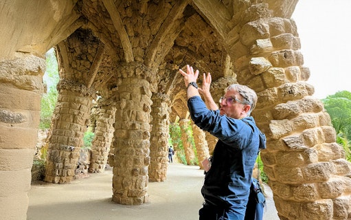 Guide explaining stone columns in Park Guell during a tour in Barcelona, Spain.