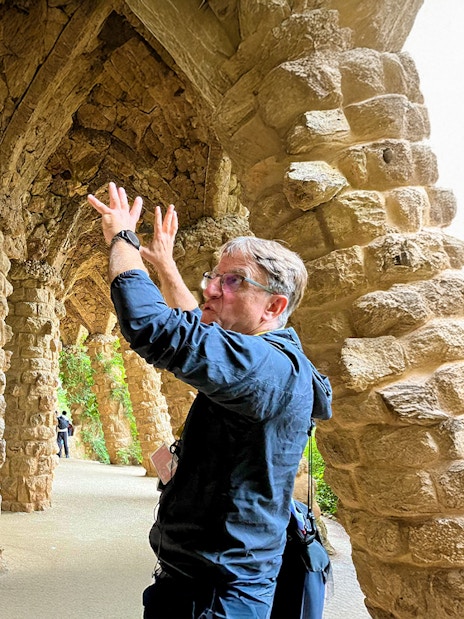 Guide explaining stone columns in Park Guell during a tour in Barcelona, Spain.
