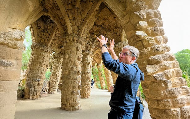 Guide explaining stone columns in Park Guell during a tour in Barcelona, Spain.
