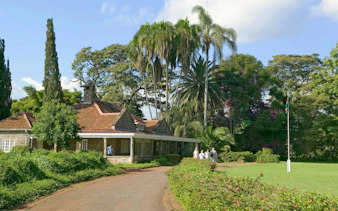 Karen Blixen Museum with visitors in lush garden, Nairobi, Kenya.