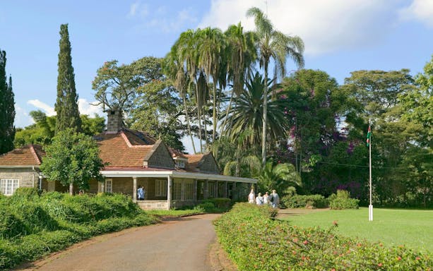 Karen Blixen Museum with visitors in lush garden, Nairobi, Kenya.