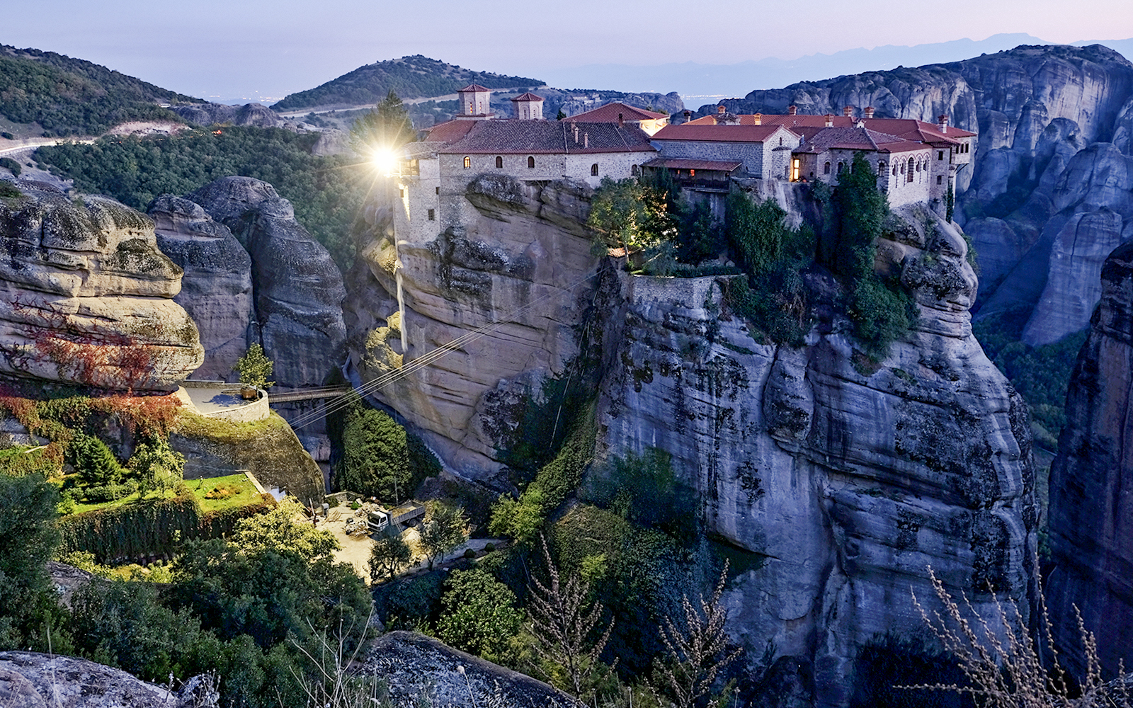 Monastery of Varlaam illuminated at night atop rock formations in Meteora, Greece.
