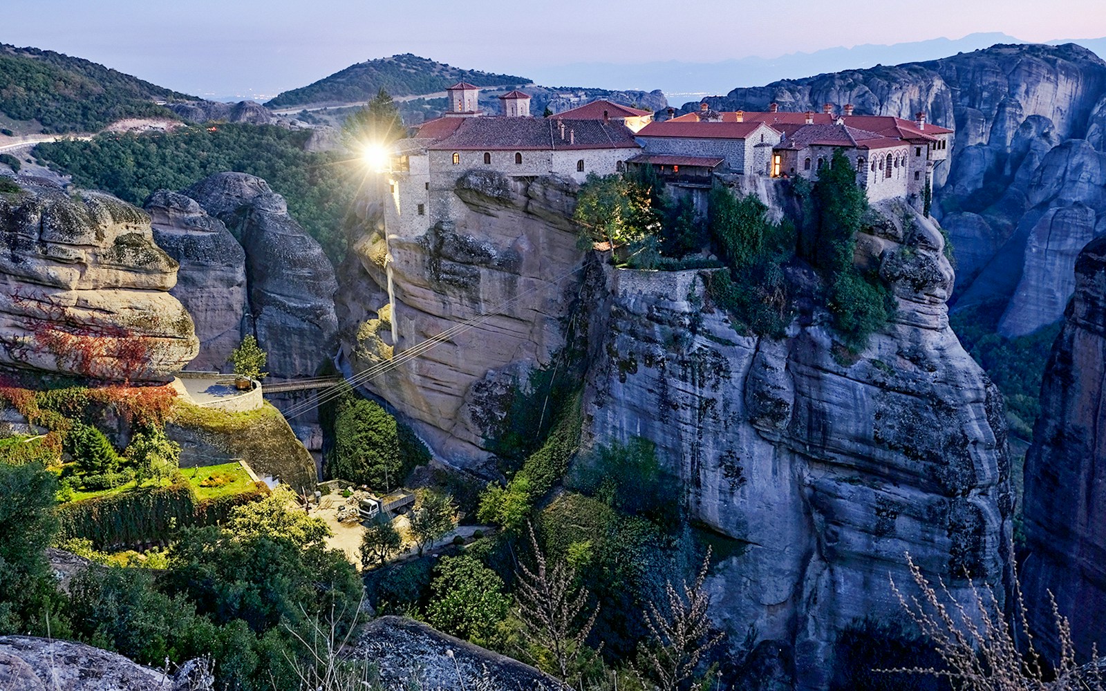 Monastery of Varlaam illuminated at night atop rock formations in Meteora, Greece.